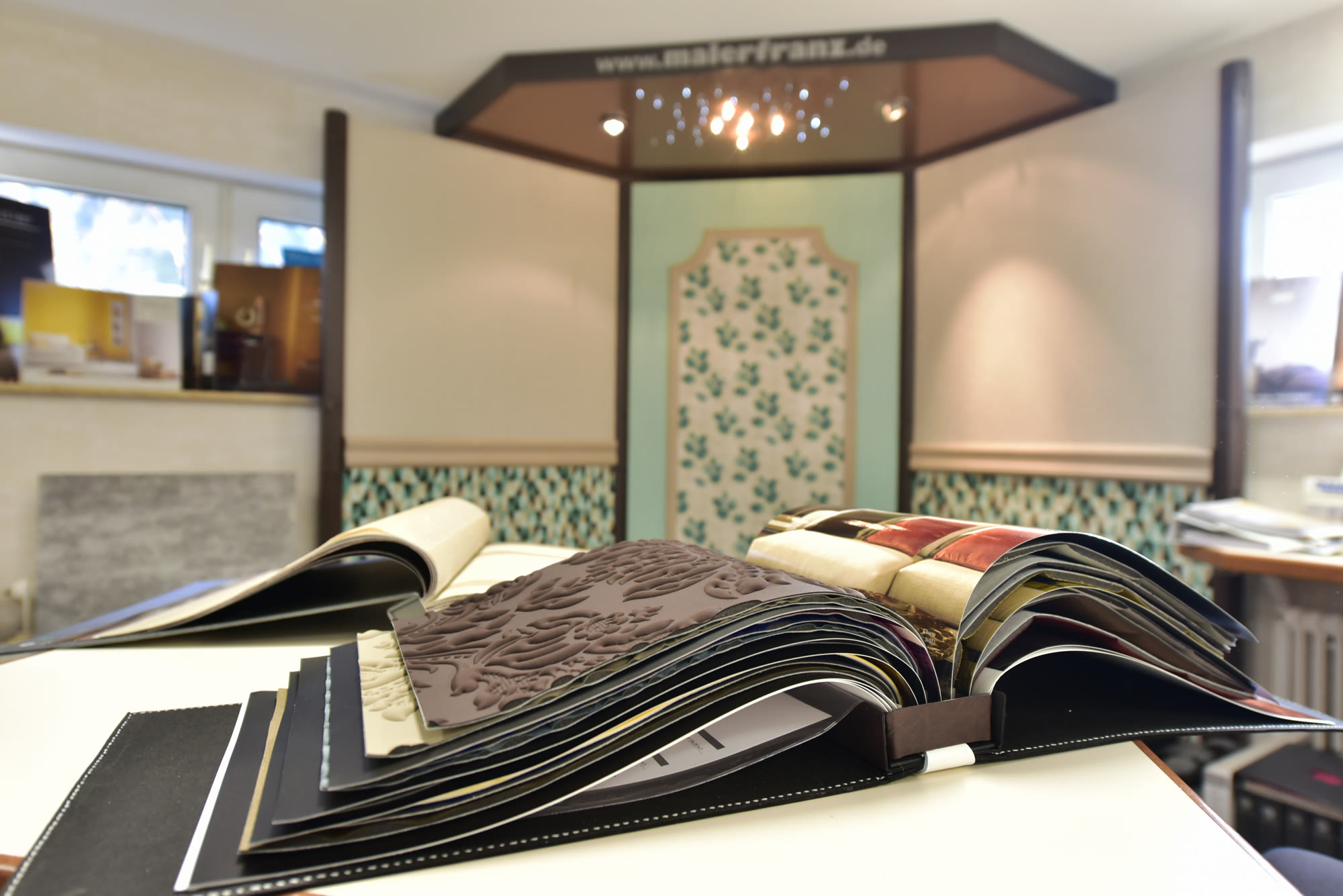 Tapetenbuch im Ausstellungsraum – Maler Franz Uhingen berät zu Tapeten und Wandgestaltung