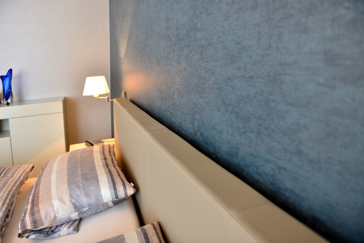 Schlafzimmer mit blauer Wandgestaltung – Tapezierarbeiten von Maler Franz
